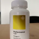 A bottle of Performance Lab Omega-3 sitting on a table in a room