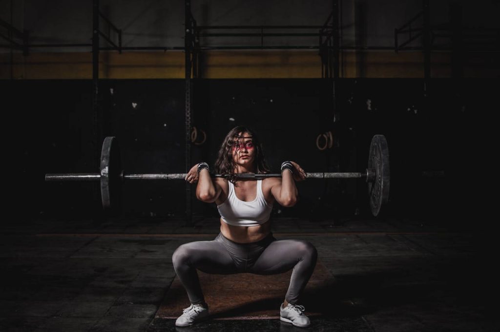 A woman doing a barbell lift.