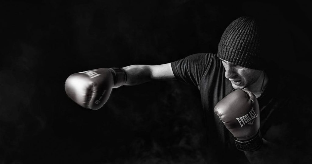 A man shadow boxing in a black and white photo.